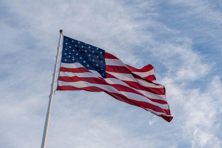 American flag waving proudly against a clear blue sky, symbolizing freedom and patriotism.